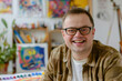 © Jasmina - Young smiling man with Down syndrome on art workshop with a group of students, learning a new skill. Social integration concept.