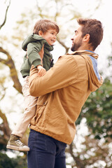 Wall Mural - Father, child and love embrace in nature for bonding connection in forest for autumn happiness, joy or care. Male person, son and holding in woods for holiday vacation or outdoor, family or together