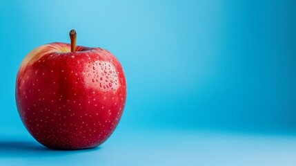 one red apple isolated on a blue background