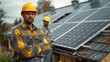 Tradesman in hard hat stands by building with solar panels