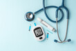 © thanksforbuying - Blood glucose meter, lancet and stethoscope on blue background, diabetes concept