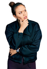 Poster - Young hispanic girl wearing sportswear with hand on chin thinking about question, pensive expression. smiling with thoughtful face. doubt concept.