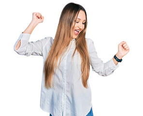 Beautiful caucasian woman wearing casual white shirt dancing happy and cheerful, smiling moving casual and confident listening to music