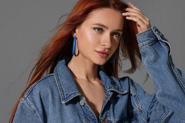 Wall Mural - Beautiful young woman in denim jacket on gray background