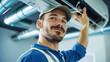 © Anoo - A man wearing a hardhat is focused on repairing an air conditioner unit in a mechanical room
