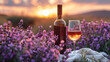A bottle of wine and a glass stand on a blanket in a lavender field