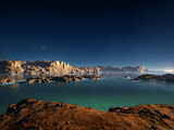 Fototapeta Łazienka - An image of the sea with mountains in the background, featuring a sky with stars.