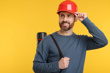 Poster - Architect in hard hat with drawing tube on orange background, space for text