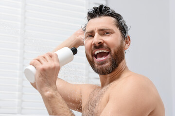 Poster - Handsome man with bottle of shampoo singing in shower