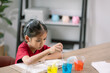© FAMILY STOCK - Asian girl making Walking Water experiment. Food color is added to the water in the glass, water moves along the paper, and then color is mixed. Concept of science for kid