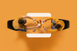 © Lustre Art Group  - Creative collage. Aerial view of two man, friends eating fast food at common table against yellow background. Copy space. Concept of business lunch, morning meeting, delivery services, briefing