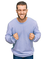 Wall Mural - Young caucasian man wearing casual clothes very happy and excited doing winner gesture with arms raised, smiling and screaming for success. celebration concept.