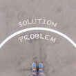 Problem and Solution, text on asphalt ground, feet and shoes on floor