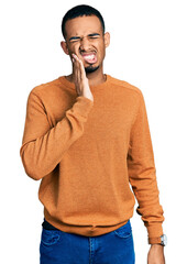 Poster - Young african american man wearing casual clothes touching mouth with hand with painful expression because of toothache or dental illness on teeth. dentist