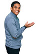 © Krakenimages.com - Young handsome hispanic man wearing casual sweatshirt pointing aside with hands open palms showing copy space, presenting advertisement smiling excited happy