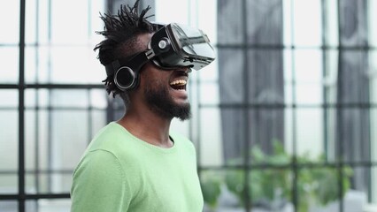 Wall Mural - Cool handsome african american man put on virtual reality goggles for the first time in the office.