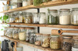 Open shelving in a kitchen with jars of dried pasta, herbs, and grains.