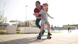 learn to skateboard. dad teaches daughter to ride a skateboard outdoors at the playground. father and daughter play training concept. parent teaching child daughter to lifestyle skateboard