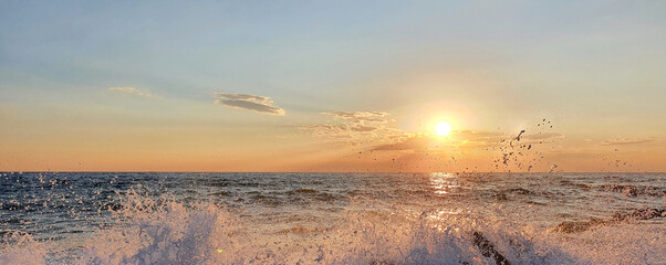 Wall Mural - colorful sunset with large sun under the sea waves.