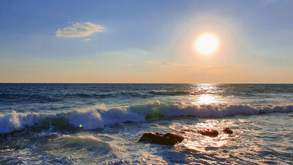Wall Mural - colorful sunset with large sun under the sea waves.