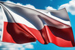 Polnische Flagge vor blauem Himmel im Wind als Hintergrund