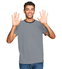 Wall Mural - Young handsome african american man wearing casual clothes showing and pointing up with fingers number ten while smiling confident and happy.