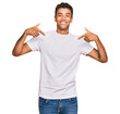© Krakenimages.com - Young handsome african american man wearing casual white tshirt looking confident with smile on face, pointing oneself with fingers proud and happy.