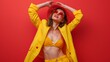 © Nataliya - Close-up portrait of happy young pretty woman in yellow suite, isolated on red background