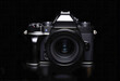 SLR camera with lens on black background. Mirrorless modern camera. Photography technology