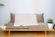 A low sofa without armrests with a blanket thrown over it