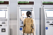 © Lili.Q - Backpacker travelers buying tickets from the automatic ticket machine at the train station