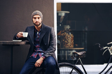 Wall Mural - Portrait, city and man drinking coffee with bicycle at cafe table for breakfast in the morning. Bike, tea cup and serious person with espresso, latte or beverage at restaurant with winter fashion