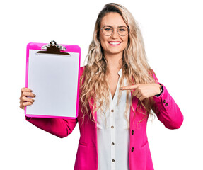 Wall Mural - Young blonde woman holding clipboard smiling with a happy and cool smile on face. showing teeth.