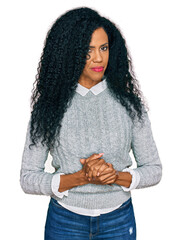 Wall Mural - Middle age african american woman wearing casual clothes with hands together and crossed fingers smiling relaxed and cheerful. success and optimistic