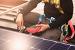 © noppadon - engineer in the Safety suite is checking and Installing solar panels on the rooftop. professional contractor