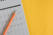 close up top view on white calendar 2024 month schedule to make appointment meeting or manage timetable each day lay on yellow background for planning work and life concept