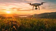 A drone with a camera hovers above a flower-strewn field during a breathtaking sunset, capturing the serene landscape and rolling hills.