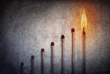 Fototapeta Kosmos - Match sticks arranged in shape of a increasing graph with the top one matchstick burning in flame. Financial chart metaphor background showing business growth or leadership concept