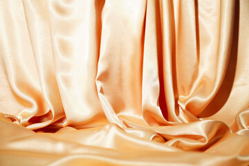 BackdropYellow silk satin  Drape fabric Gold color Luxurious background. Beautiful wavy area for design, blurred or blurred.