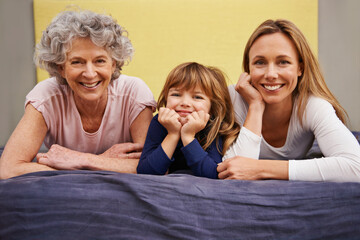 Wall Mural - Kid, mother and grandmother in bed with child, support and bonding together with a smile. Happy, family and love with mom in the morning in a girl bedroom with youth in a house with grandparent