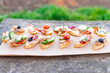 Finger food , various canapes with vegetables, ham, bacon , cheese and olives.