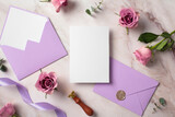 Fototapeta Mapy - Wedding invitation card template. Top view photo of blank paper card, purple envelopes, ribbon, rose flowers on marble background.