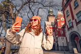Fototapeta Paryż - Tourist girl taking selfie photo against Subotica town hall, while travelling in Serbia