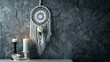 Gray dream catcher and white bedside table in bedroom interior on dark gray textured background. Bedroom decor