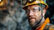 Close-up of a seasoned miner with a headlamp and safety glasses, his face tells stories of many years spent working underground.