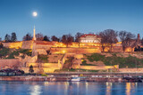 Fototapeta Paryż - iconic Kalemegdan: A symbol of Serbia's capital, where people gather to admire the historic fortress and panoramic views at full moon at night