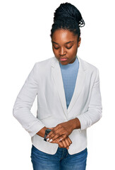 Poster - Young african american woman wearing business clothes checking the time on wrist watch, relaxed and confident