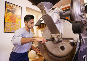 Wall Mural - Man, machine and industry for grinding coffee with roast, process and flavor for export in factory. Person, employee and tools for caffeine, beans or press with manufacturing at warehouse in Colombia