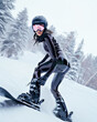A female snow boarder is ripping the trails in a fashionable latex sportswear