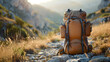 Brown filled tourist hiking backpack that stands on the ground. Mountainous terrain in the background. Concept of mountain and hiking tourism in summer